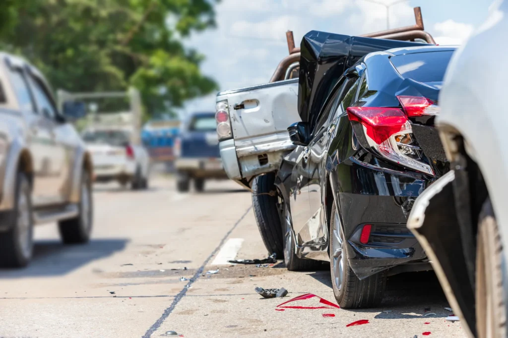 Collision on a sunny street shows a damaged black sedan and a blue pickup near Riverside, image for Martinez & Schill LLP